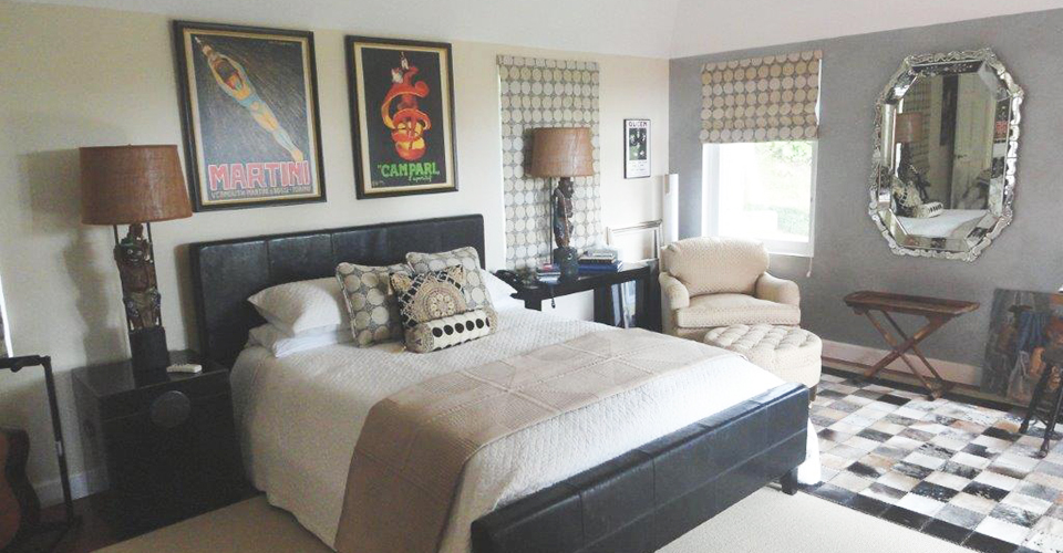 A black and white themed bedroom with large mirror and lamps