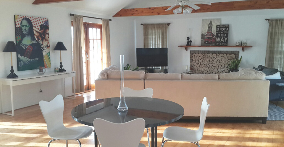 A brighly lit living and dining room area with a fireplace and tv