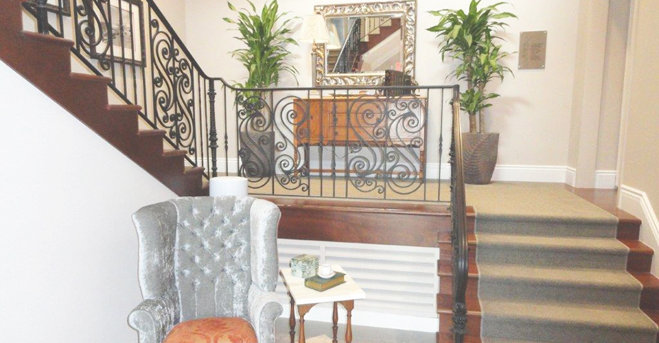 A warm staircase with matching plant and comfortable sofa chair